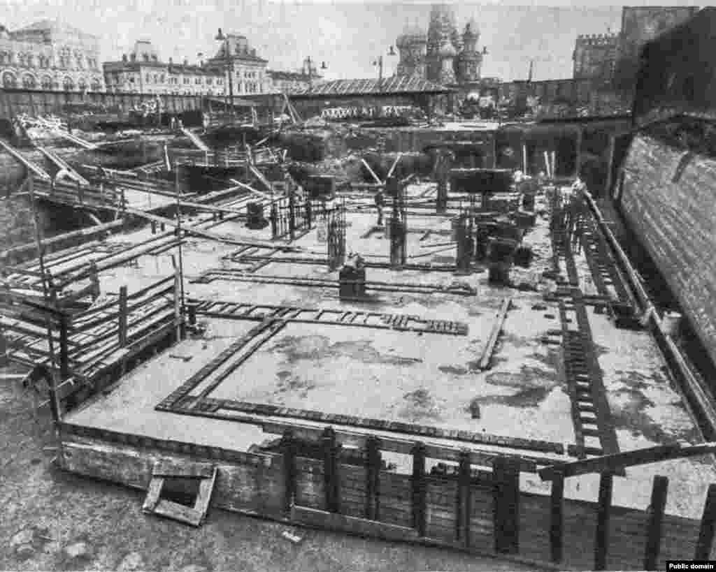 Fundațiile mausoleului lui Lenin în curs de construcție, la sfârșitul anilor 1920. Arhitectul Aleksei Șciusev a prezentat o schiță pentru un mausoleu din granit roșu și negru, care să înlocuiască și să sintetizeze planurile celor două construcții anterioare din lemn. Proiectul lui a câștigat concursul, în cele din urmă. Granitul negru trebuia să reprezinte &bdquo;doliul&rdquo;, în timp ce profilul în trepte al mausoleului sugerează ideea că &bdquo;Deși Lenin a murit, opera sa continuă să trăiască&rdquo;, a explicat el mai târziu.