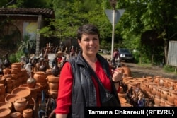 Zoja Giorgadze, koja decenijama prodaje keramiku pored puta u Šroši, pored svoje tezge.