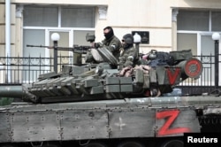 Бойовики приватної групи найманців «Вагнер» на броньованій машині на вулиці біля штабу Південного військового округу в місті Ростові-на-Дону, Росія, 24 червня 2023 року