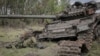 Cadavrul unui soldat rus lângă un tanc rusesc distrus, în satul proaspăt eliberat Storozheve din regiunea Donețk, Ucraina, 14 iunie 2023.