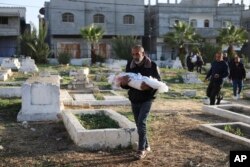 Palestinci nose tijela porodice Dhair, ubijene u izraelskom bombardovanju Pojasa Gaze, tokom njihove sahrane u Rafi, 22. decembra