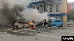 Zjarrfikësit duke e shuar zjarrin në disa vetura në Belgorod, pas raportimeve për një sulm ukrainas, 30 dhjetor 2023.