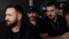 Fostul ministru Darius Vâlcov (centru) pe Aeroportul Otopeni, flancat de polițiști, în ziua în care a fost extrădat din Italia, 14 august 2023.