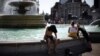 Ljudi se rashlađuju pored fontane na Trgu Trafalgar u Londonu, 19. juli 2022. 