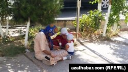 Türkmenistan, çagalary bilen köçede dilegçilik edýän aýal