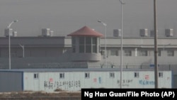 Sinjiangdaky "gaýtadan terbiýeleniş lagerlerinden" biri. Hytaýyň demirgazyk-günbataryndaky welaýatdan bolan ýerli ilat zor bilen ýapyk edaralara ýerleşdirildi.