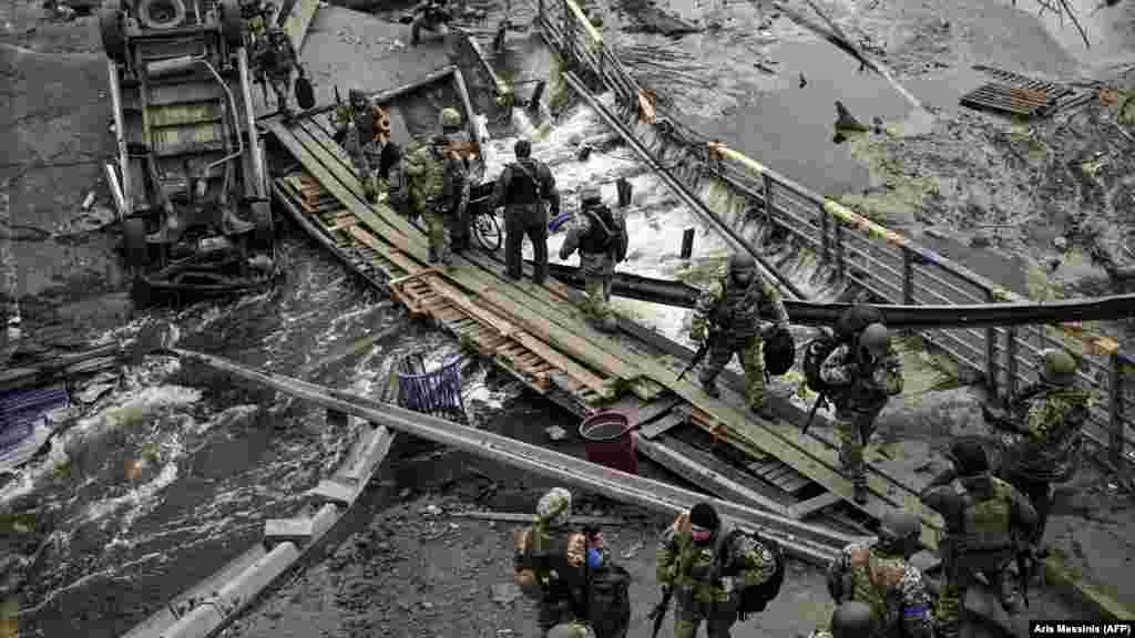 UKRAINE -- Ukranian servicemen walk on a makshift pathway