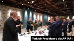 Президент Турции Реджеп Тайип Эрдоган (стоит спиной) и российская (справа) и украинская делегации перед возобновлением переговоров. Стамбул, 29 марта 2022 года