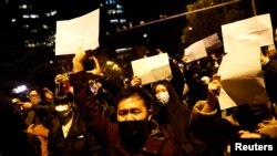 Učesnici protesta u Kini zbog strogih kovid ograničenja drže prazne bele listove papira, Peking 27. novembar 2022.
