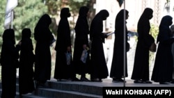 Afghan female students queue for entrance exams at Kabul University on October 13. The Taliban has issued restrictions controlling women's lives, blocking girls from returning to secondary schools and barring women from many government jobs.