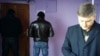 Юрист Сергей Уткин (справа) у входа в офис редакции Nakanune.kz, доступ к которому заблокирован мужчинами в штатском. В помещении редакции ведется обыск. Алматы, 18 декабря 2015 года. 