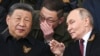 Президент России Владимир Путин и лидер Китая Си Цзиньпин беседуют на трибуне во время военного парада в честь Дня Победы в Москве. 9 мая 2025 года