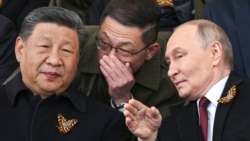Президент России Владимир Путин и лидер Китая Си Цзиньпин беседуют на трибуне во время военного парада в честь Дня Победы в Москве. 9 мая 2025 года