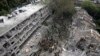 Punonjësit e shpëtimit dhe zjarrfikësit inspektojnë vendin e goditur drejtpërdrejt nga një raketë e lëshuar nga Irani në Tel Aviv, Izrael, të dielën, më 22 qershor 2025.