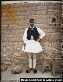 Kestri şäherinden bolan milli egin-eşikli adam, Gresiýa, 1912-nji ýyl. Suratçy ol adamyň boýunyň "azyndan 1,8 metr" bolandygyny belläpdir.