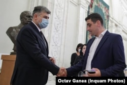 Liderul PSD, Marcel Ciolacu, și liderul AUR, George Simion, strângându-și mâinile înaintea votului moțiunii de cenzură contra caninetului Cîțu, 5 octombrie 2021.