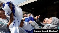 Izraelci i Palestinke u muslimanskoj četvrti Stari gradu u Jerusalimu, tokom izraelskog nacionalističkog "Marša zastave", 29. maj 2022. 