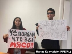 Karagoz Kasim (levo) i Ajsultan Kudajbergen privedeni su na aerodromu u Almati dok su držali natpise na kojima je pisalo: "Da li shvatate da ste topovsko meso?" i "Ili poštuj ili odlazi".