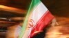 A supporter of Iranian President Mahmud Ahmadinejad waves the national flag in Tehran at a rally ahead of the vote.