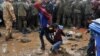 Migranți și refugiați așteaptă în ploaie și noroio să treacă frontiera dintre Grecia și Macedonia în satul grecesc Idomeni, nordul Greciei, 10 septembrie 2015.