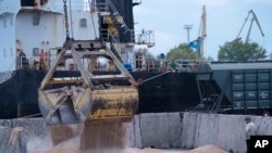 Workers load grain at a port in Izmail, Ukraine, on April 2023.