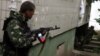 Боец "Луганской народной республики" стреляет из жилых кварталов во время штурма управления луганского пограничного отряда
