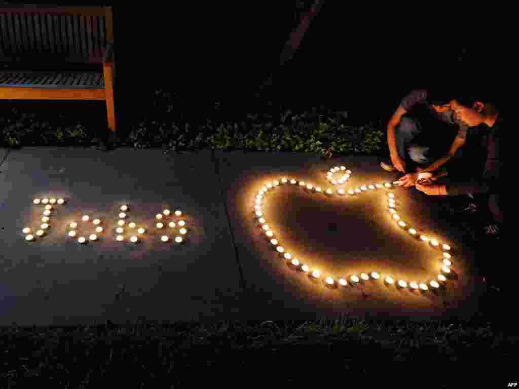 Chinese exchange students use candles to create the Apple logo and spell out the late CEO's name in a tribute in Cupertino, California, on October 5.