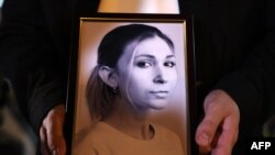 Портрет Виктории Рощиной в руках ее коллеги во время акции памяти опгибшей журналистки