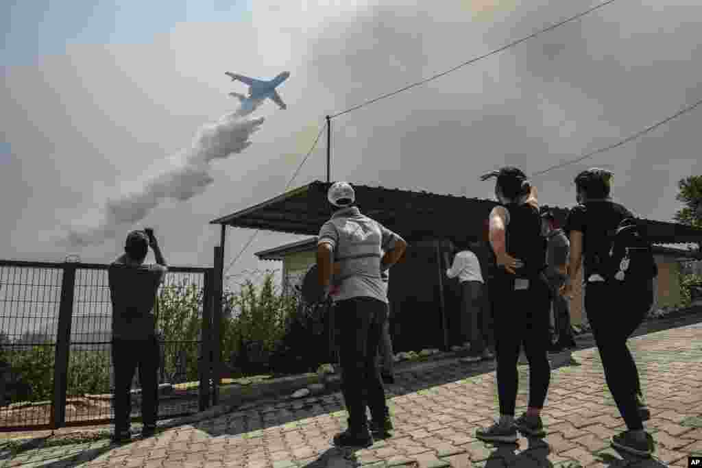 Një aeroplan duke hedhur ujë për shuarjen e flakëve masive mbi fshatin Sirtkoi, afër Manavgatit, në Antalia. (1 gusht).
