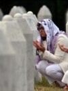 Боснийские мусульманки молятся у могил своих родственников на мемориальном кладбище в Сребренице
