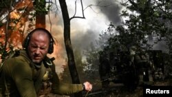 Боец 110-й отдельной бригады войск ТРО ВСУ ведет огонь из гаубицы по российским захватчикам на передовой в Запорожской области. Украина, 16 июня 2025 года