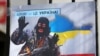 Плакат із зображенням Володимира Путіна у вигляді «зеленого чоловічка» під час акції «Крим – це Україна» біля російського посольства у Києві, 16 березня 2020 року