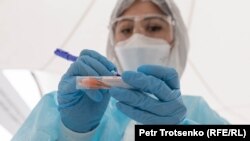 Një punonjëse shëndetësore në Kazakistan duke shënuar mbi një mostër të testit ndaj COVID-19. 