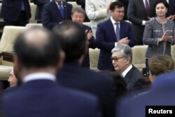 Gazagystanyň prezidenti wezipesini ýerine ýetiriji Kasym-Žomart Tokaýew (sagda) we onuň halypasy Nursoltan Nazarbaýew (çepde ýüzi görünýär)