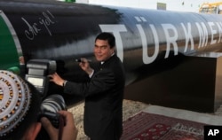 Öňki prezident Gurbanguly Berdimuhamedow gaz turbasyna gol çekýär. 2010 ý,