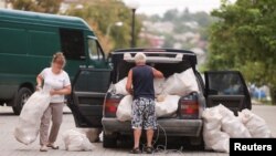 Ljudi dobijaju hleb tokom podele humanitarne pomoći u Bahmutu 26. avgusta.