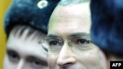 Bivši generalni direktor naftne kompanije Jukos Mihail Hodorkovski (lijevo) stoji pored svog bivšeg poslovnog partnera Platona Lebedeva (desno), iza staklenog zida u sudnici, u Moskvi, 27. decembar 2010.