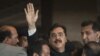 Pakistanyň premýer-ministri Ýusuf Reza Gilani suduň zalyndan ýylgyryp we tarapdarlaryna elini salgap çykdy. Yslamabat, 26-njy aprel, 2012.