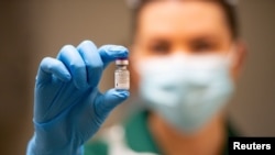 Ковентри шаарындагы оорукананын медайымы Pfizer жана BioNTech вакцинасын кармап турат. Улуу Британия. 2020-жылдын 8-декабры.