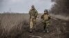 Капелан Андрій Зелінський (праворуч) веде розмову з морським піхотинцем Павлом, який супроводжував нас до передових позицій під Водяним