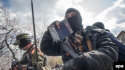 Un separatist inarmat in Sloviansk isi aratã pasaportul ucrainean.