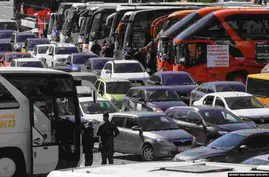 Киевде өткөн нааразылык акциясы учурунда автобус, унааларын жолго токтотуп койгон ишкерлер. Алар бийликтен жумушка чыгарууну талап кылып митингге чыгышкан. Киев, Украина. 13-май, 2020-жыл. 