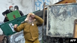 Un manifestant în vârstă își exprimă satisfacția după ce a țintit bine cu un cocktail Molotov.