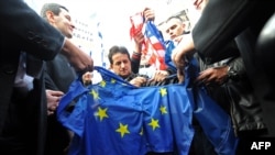 Pristalice SRS-a cepaju zastavu SAD i EU na jednom od protesta u Beogradu, novembar 2013.