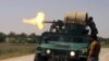Policemen fire from an armored vehicle during a battle with insurgents in Kunduz province on May 3.