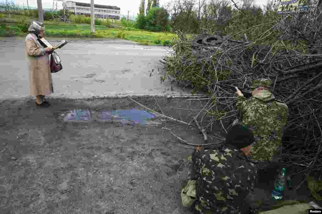 Жінка читає Біблію біля позиції проросійськіх бойовиків на околиці Слов&rsquo;янська, 5 травня 2014 року