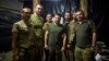 Președintele ucrainean Volodimir Zelenski pozează cu militarii în timpul vizitei sale la cartierul general al brigăzilor de pe linia frontului de lângă Soledar, regiunea Donețk, Ucraina, 14 august 2023.