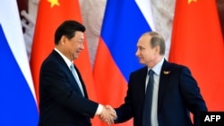 Russian President Vladimir Putin (right) shakes hands with his Chinese counterpart Xi Jinping in Moscow on May 8. 