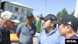 Марсбек Кыдыкбаев саясий кысымга кабылышын агасы Кубанычбек Кадыровдун ишмердиги менен байланыштырууда. (Сүрөттө: ЖКнын мурдагы депутаты Кубанычбек Кадыров (оңдон экинчи) Балыкчыдагы шайлоо күнкү тополоң учурунда, 23-июль, 2009-жыл.) 