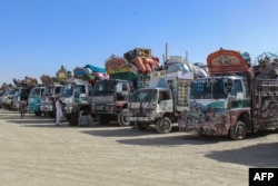 Owgan bosgunlary Pakistanyň Çaman serhediniň golaýynda Owganystana gitmezden ozal goş-golamlary bilen ýük awtoulaglarynyň ýanynda garaşýarlar. 27-nji aprel, 2025.